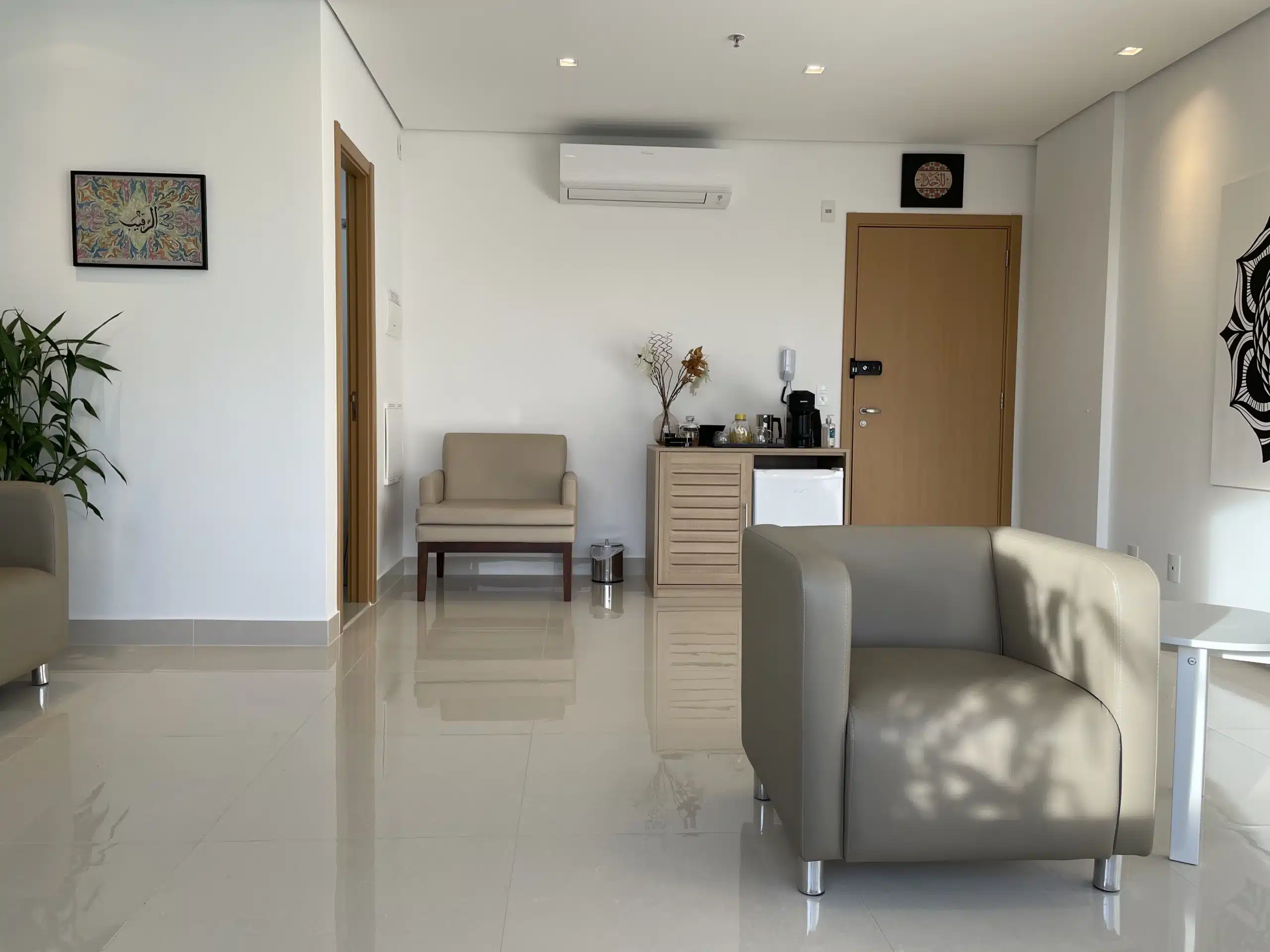 Sala de espera de consultório de psicologia com ambiente organizado, iluminação natural e mobiliário confortável