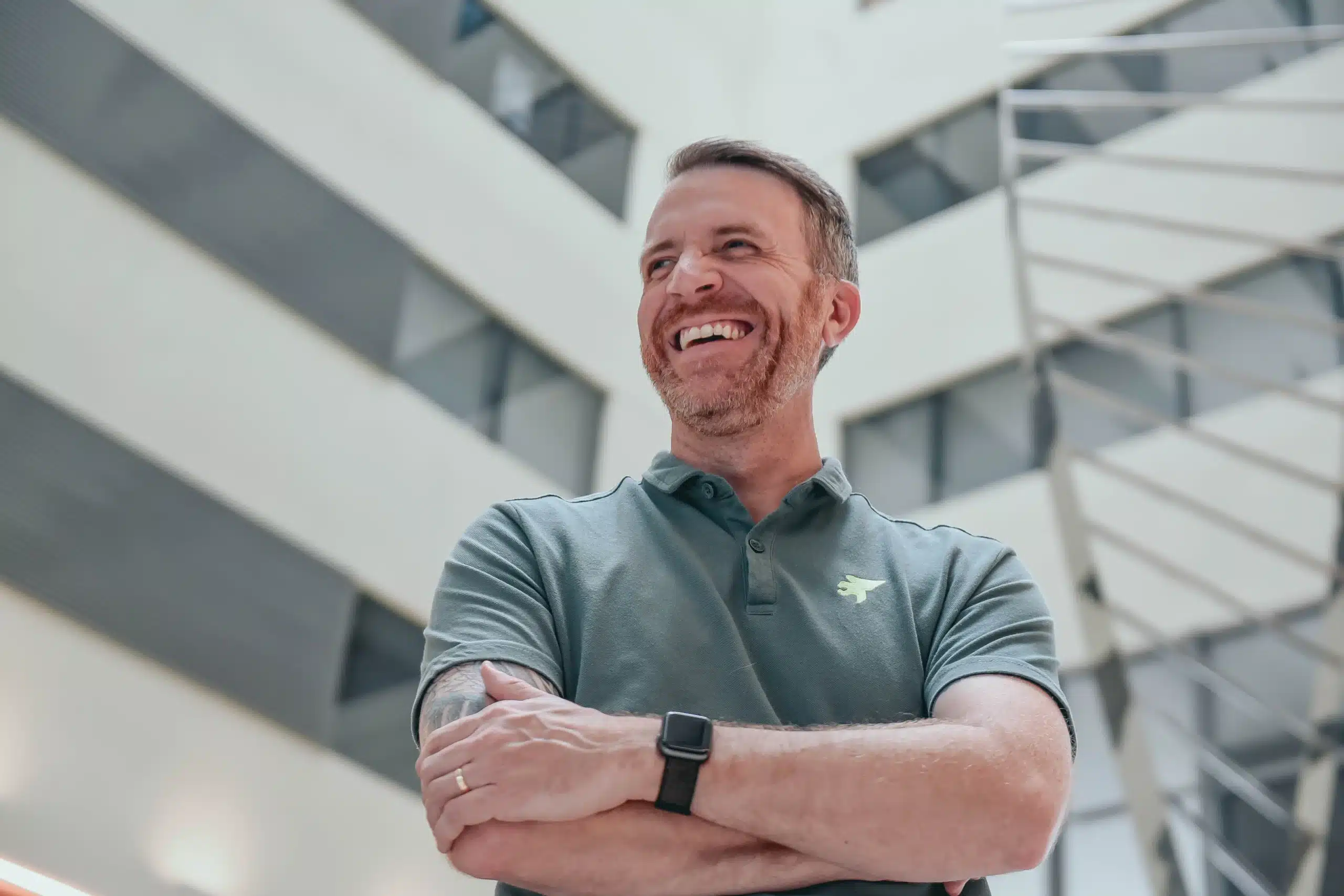 Psicólogo em retrato profissional, sorrindo, em ambiente institucional contemporâneo